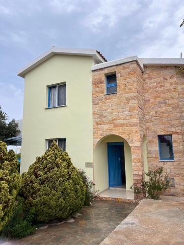 a brick house with a blue door at QUEEN EVRIDIKI & VILLA PANORAMA in Peyia