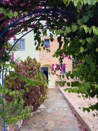an archway with pink flowers in front of a building at QUEEN EVRIDIKI & VILLA PANORAMA in Peyia