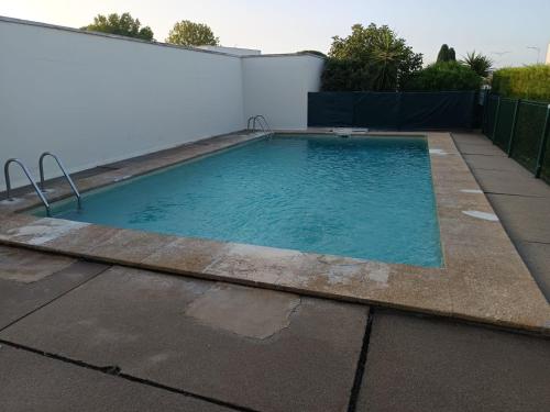 - une piscine sur le côté d'une maison dans l'établissement L'Hacienda studio cosy 4 pers dans une résidence calme avec piscine belle terrasse coin nuit séparé à 300 m de la plage, au Grau-du-Roi