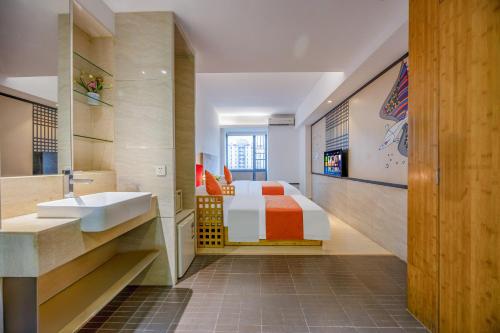a bathroom with a bed and a sink in a room at Guangzhou Timmy Hotel in Guangzhou