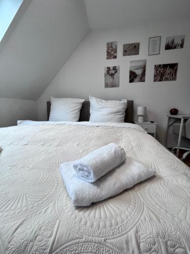 a white bed with two towels sitting on it at Fe-Wo im Herzen von Weingarten in Niederdorla