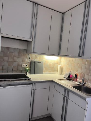 a kitchen with white cabinets and a sink at Fe-Wo im Herzen von Weingarten in Niederdorla