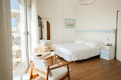 a bedroom with a bed and a desk with a chair at Hotel Las Vegas in Lido di Jesolo