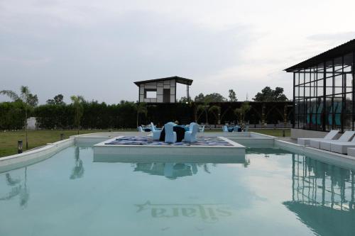 a swimming pool with blue water in front of a building at Sitara Palace and Resort in Bhopal