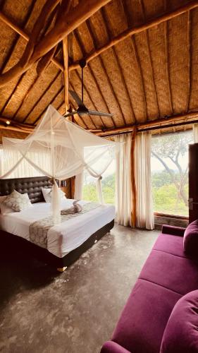 a bedroom with a large bed with a mosquito net at Yoga bale house in Padangbai
