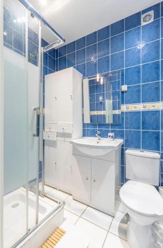 La salle de bains est pourvue de carrelage bleu, de toilettes et d'un lavabo. dans l'établissement Soleil Couchant Balcon Parking Metz Gare Un-Séjour-à-Part, à Metz