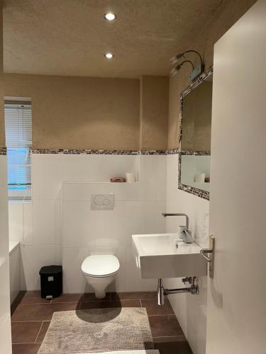 ロイタッシュにあるApartment Nalaの白いトイレと洗面台のあるバスルーム