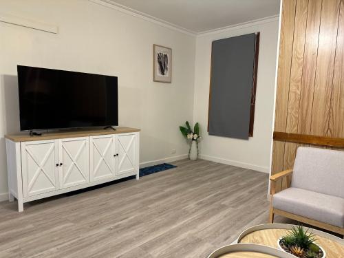 a living room with a flat screen tv on a white cabinet at Shore Getaway Spirit of Tasmania- 2 Mins in Norlane