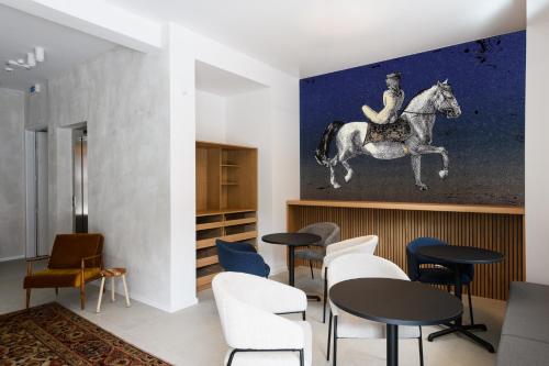a room with tables and a horse painting on the wall at Hiša Barbara in Celje