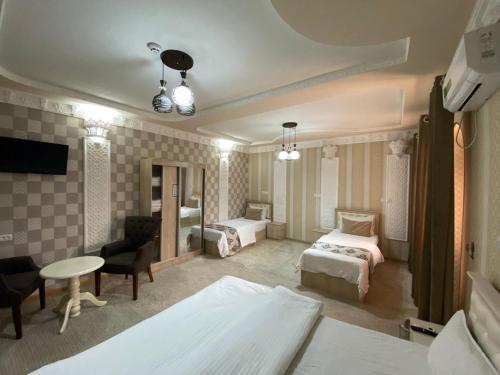a hotel room with a bedroom with two beds at Hotel El Emir in Samarkand