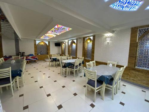 a restaurant with tables and chairs and a stained glass ceiling at Hotel El Emir in Samarkand