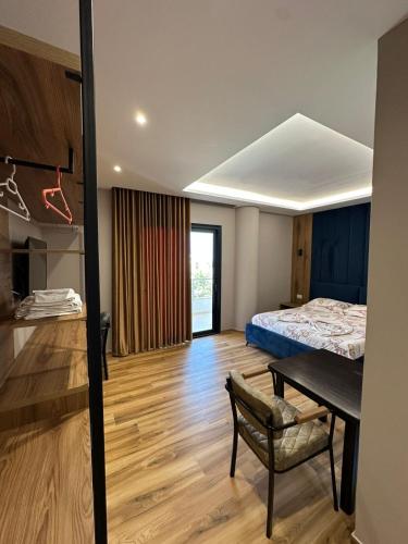 sypialnia z łóżkiem, stołem i krzesłem w obiekcie New Donantelo Hotel we Wlorze