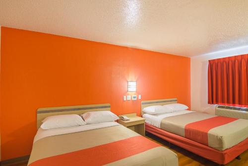two beds in a room with orange walls at Motel 6-Indianapolis, IN - Airport in Indianapolis
