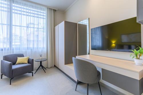 an office with a desk and a chair and a tv at CityZen - Boutique Studios in Achrafieh in Beirut