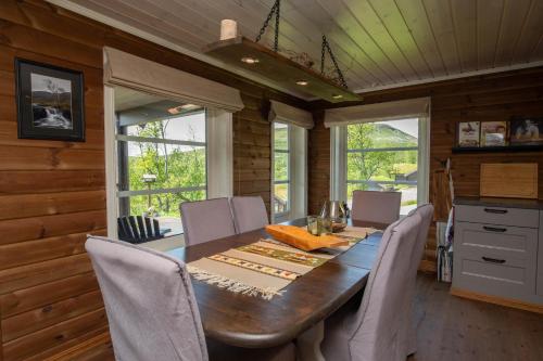 a dining room with a long table and chairs at Vakker hytte med fantastisk utsikt in Geilo
