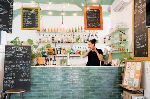 a man talking on a cell phone at a bar at YASI Hostel in Lyon