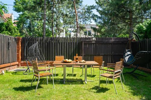 a backyard with a table and chairs and a swing at Urban Spa House Jacuzzi, Sauna, Taras & Grill ! No Parties in Warsaw