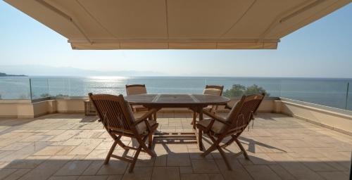 ein Tisch und Stühle auf einem Balkon mit Blick auf das Meer in der Unterkunft Koroni Seaside Private Beach Residence A in Koroni