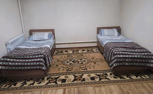 two beds sitting next to each other in a room at Guest house Comfort in Naryn