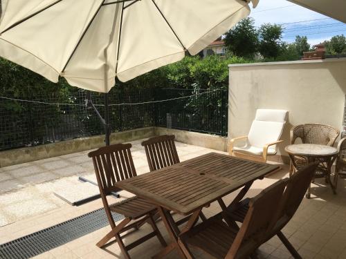 a wooden table and chairs with an umbrella on a patio at Casa Vacanze Marina Vecchia in Senigallia