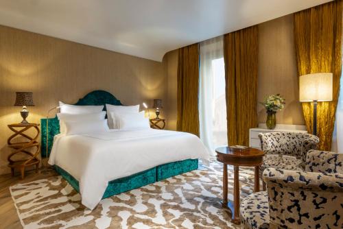 a hotel room with a bed and a chair at The James Suite Hotel Firenze 1564 - Small Luxury Hotels of the World in Florence