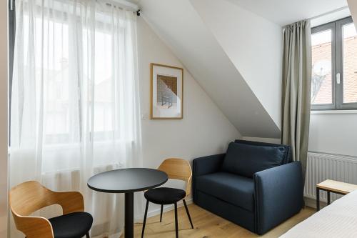 a living room with a blue chair and a table at Hiša Barbara in Celje