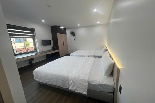 a small bedroom with two beds and a window at Thao Trang Luxury Hotel Quang Binh in Dong Hoi