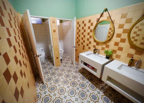 a bathroom with a sink and a mirror and a toilet at Sugar and Spice Inn in Kata Beach