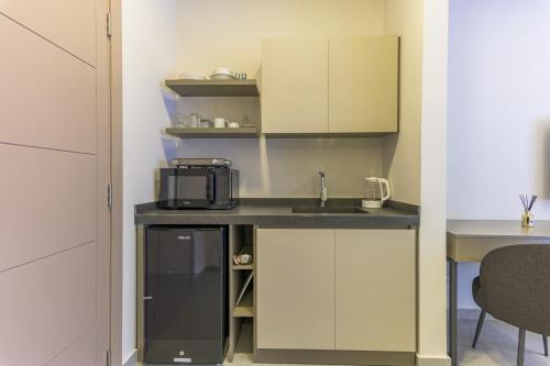 a small kitchen with a sink and a microwave at CityZen - Boutique Studios in Achrafieh in Beirut
