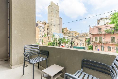 a couple of chairs and a table on a balcony at CityZen - Boutique Studios in Achrafieh in Beirut