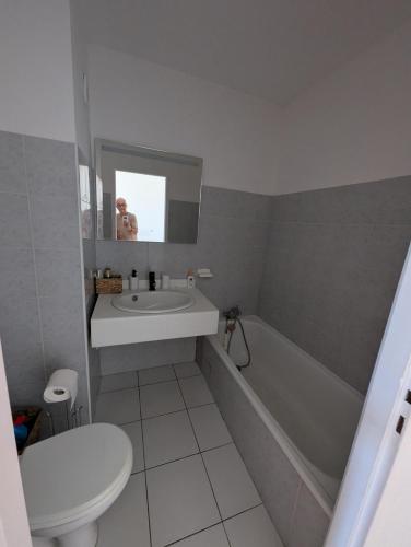 une salle de bain avec un lavabo, une baignoire et des toilettes dans l'établissement Cala Di sognu Moriani plage face à la mer, à San-Nicolao