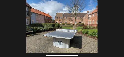 a ping pong table sitting on a brick patio at Sandy Bottom in Filey