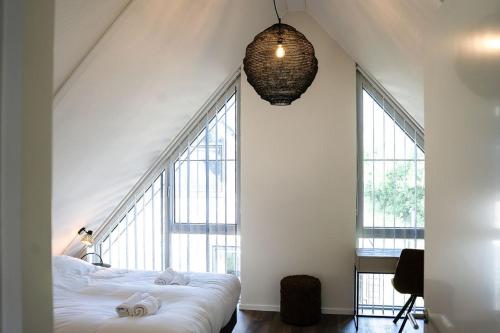 a bedroom with a bed and a large window at Wetterfrij - Enjoying the water in Elahuizen in Elahuizen
