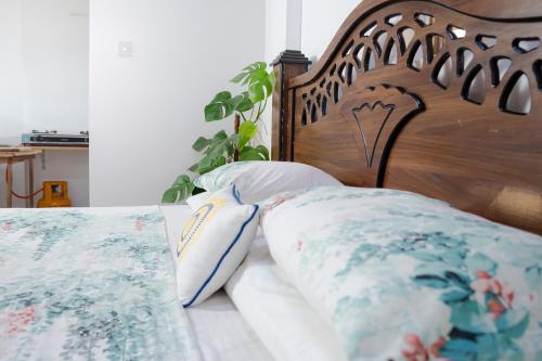 a bed with a wooden headboard and pillows on it at House of Sincerity in Maharagama