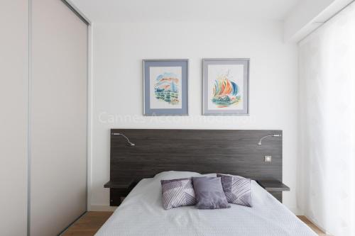 une chambre avec un lit avec trois tableaux au mur dans l'établissement Sparkle, à Cannes