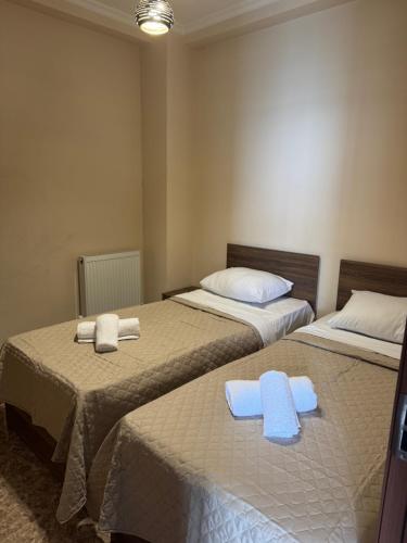two beds in a room with towels on them at Tiko's Apartments in Gonio in Gonio