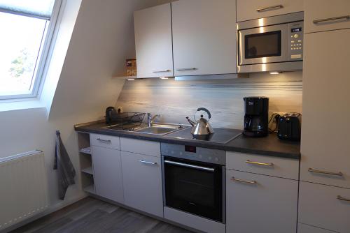 eine Küche mit Spüle und Teekessel in der Unterkunft Studiowohnung mit dem gemütl Flair in Döse