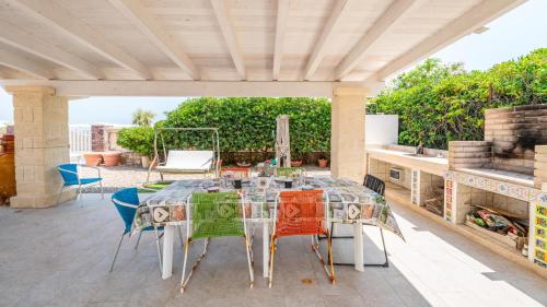 Villa Petronilla sul Mare by Rentbeat في سافيلّيتري دي فاسانو: فناء على طاولة وكراسي على السطح