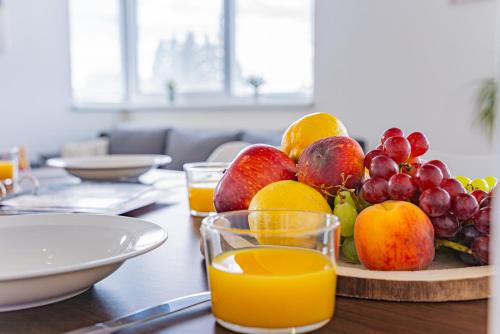 un piatto di frutta su un tavolo con bicchieri di succo d'arancia di Luxusný, plne zariadený, súkromný apartmán s klimatizáciou neďaleko historického kúpeľného mesta Bojnice a Nováky