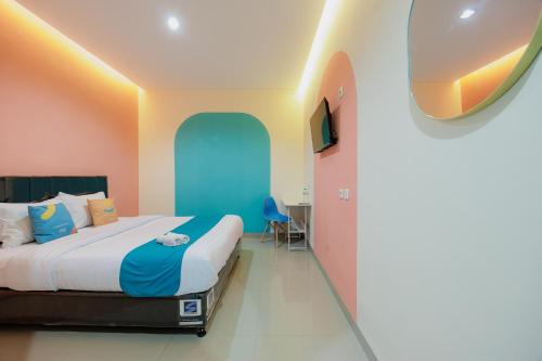 a hotel room with a bed and a tv at Sans Hotel Harapan Indah in Pulokendal