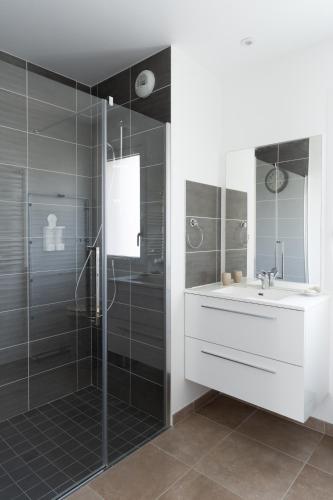 a bathroom with a shower and a sink and a mirror at Le Marnier - Moderne & Central in Montaigu-Vendée