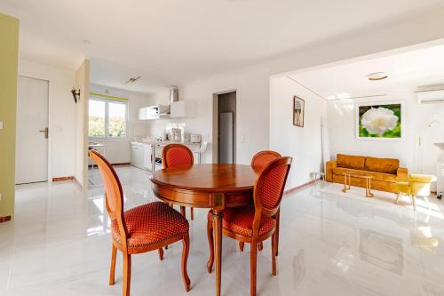 une cuisine et une salle à manger avec une table et des chaises en bois dans l'établissement Maison indépendante 52 m2, clim, wifi et jardin, à La Londe-les-Maures