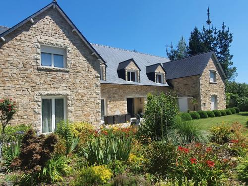 a stone house with a garden in front of it at Les Centauris in Pléguien
