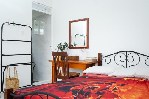 a bedroom with a bed and a desk and a mirror at House of Sincerity in Maharagama
