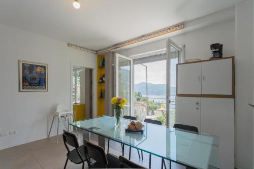 a dining room with a glass table and chairs at La Casa dell'Architetto by Rent All Como in Blevio