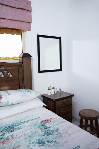 a bedroom with a bed and a table and a mirror at House of Sincerity in Maharagama