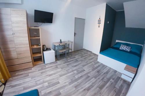 a small room with a bed and a table at Dom Gościnny Wika in Rewal