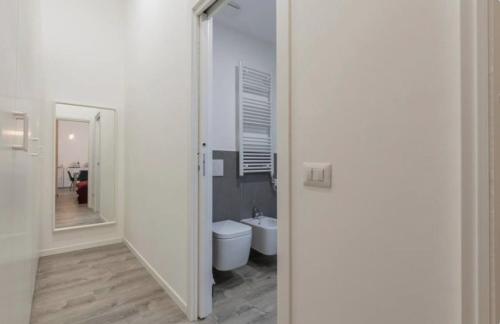 a white bathroom with a toilet and a mirror at I-Host Apartment - Gallura 11-2 in Milan