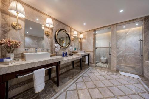 a bathroom with two sinks and a mirror and a shower at Liman Hotel & Casino by Merit in Kérynia