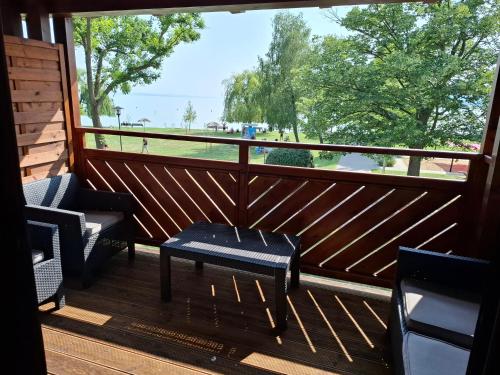 a porch with two chairs and a table and a window at Beachfront Apartman in Balatonfůzfő